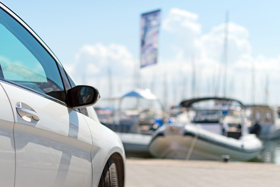 Auto, Boat, and Motorcycle Insurance Quote - Car Parked Near Next to the Pier With Boats Blurred in the Distance on a Sunny Day